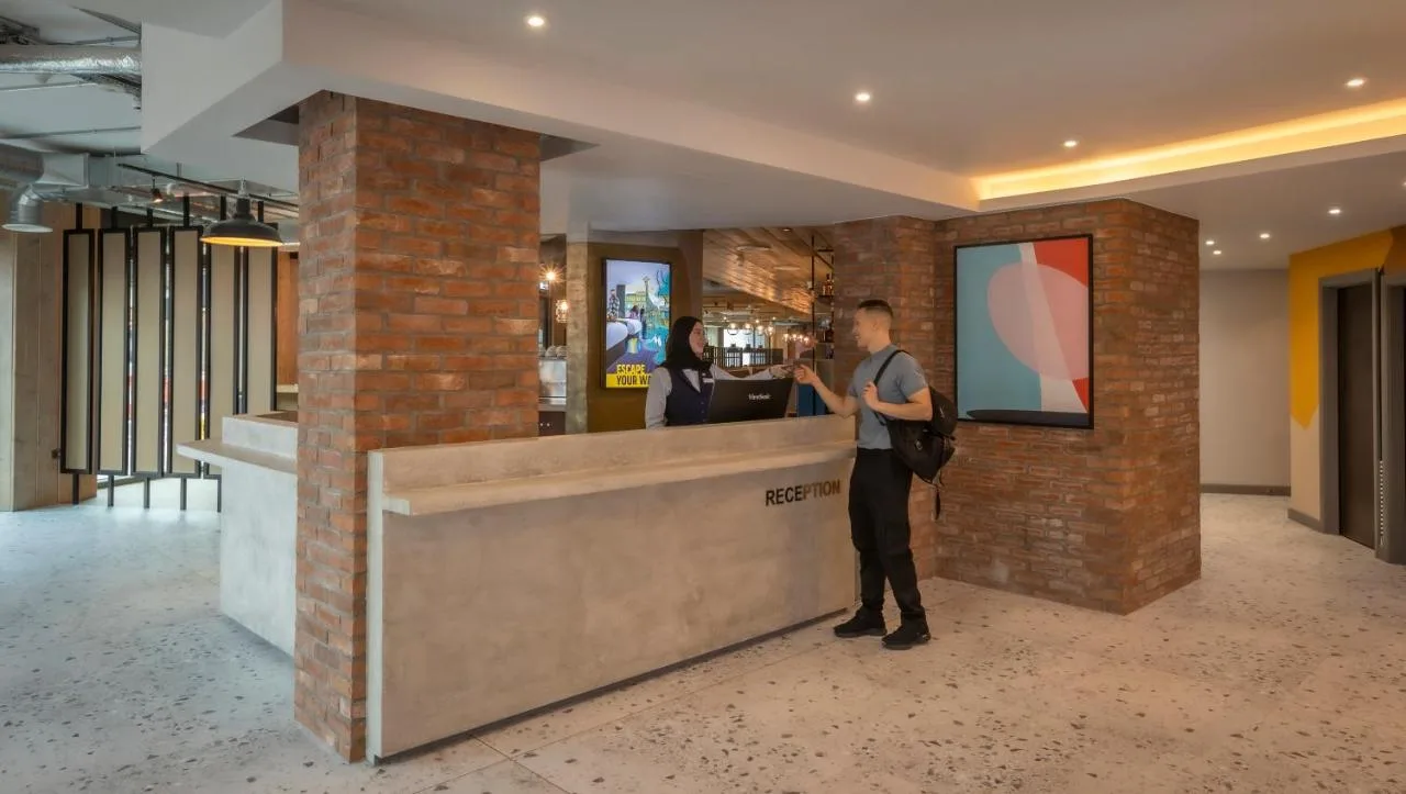 A man standing at the bar counter at Maldron Hotel Finsbury Park, London
